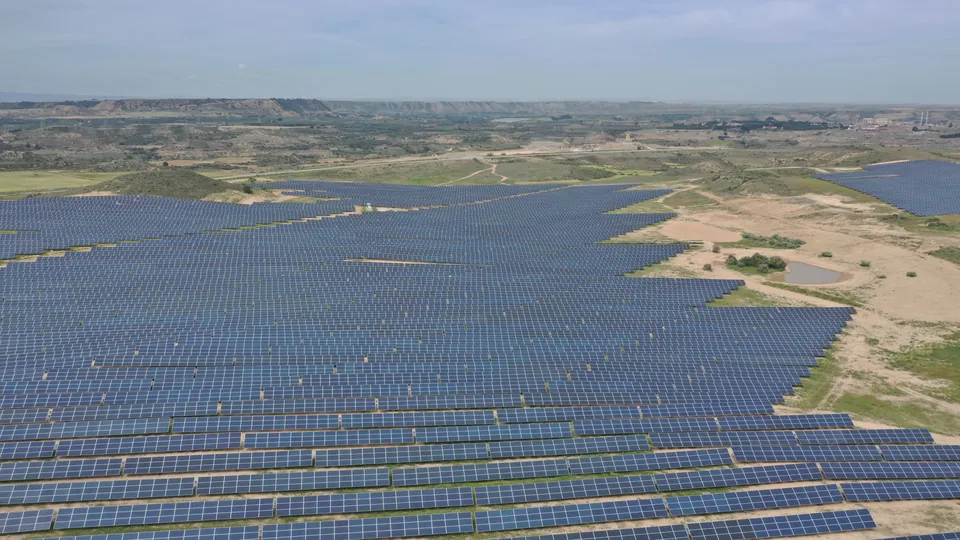 Drone aerial view of photovoltaic plant and wind turbines